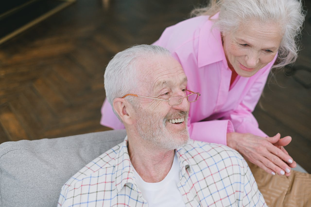 Elderly couple enjoying affectionate conversation at home.